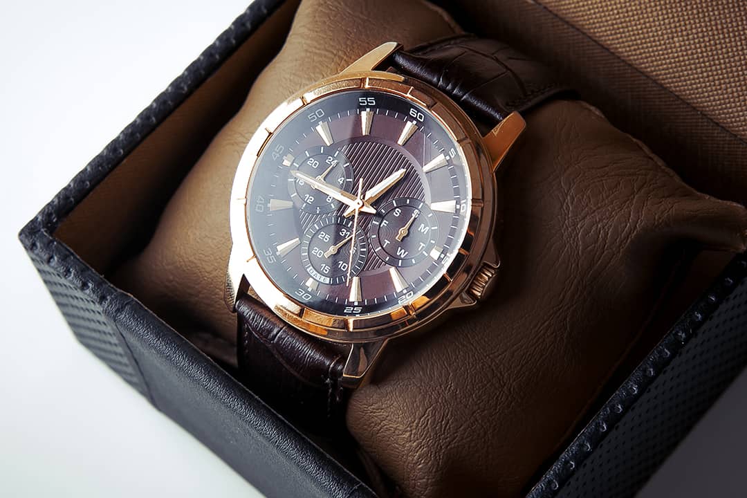 A luxury men's wristwatch in bronze and black leather colorway.